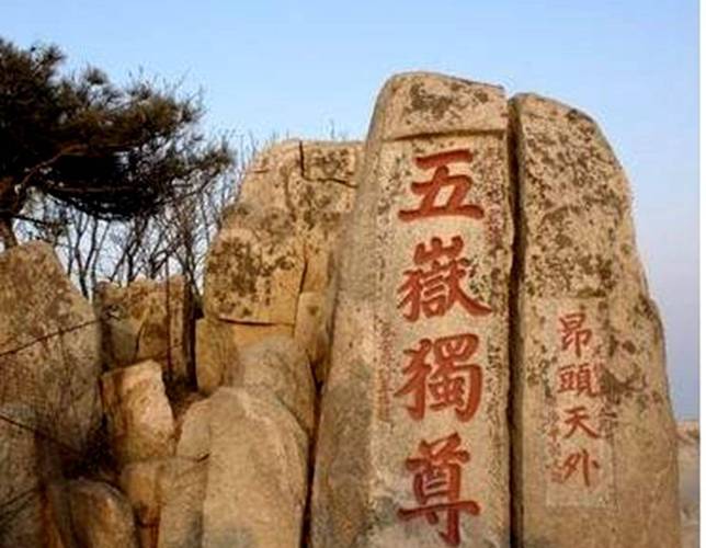 男子攀爬五岳独尊石,游客爬上五岳独尊石刻拍照